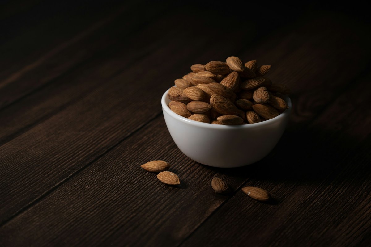 Bol d'amandes entières posé sur une table sombre