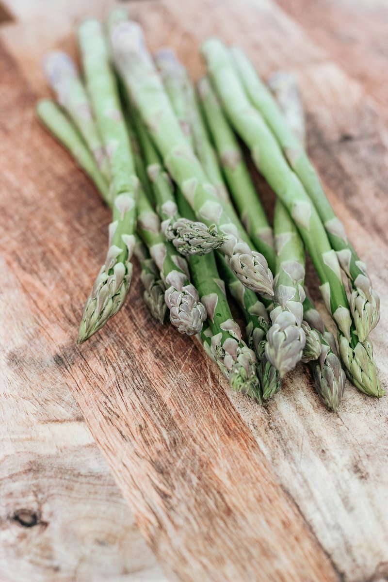 Asperges vertes sur une planche en bois