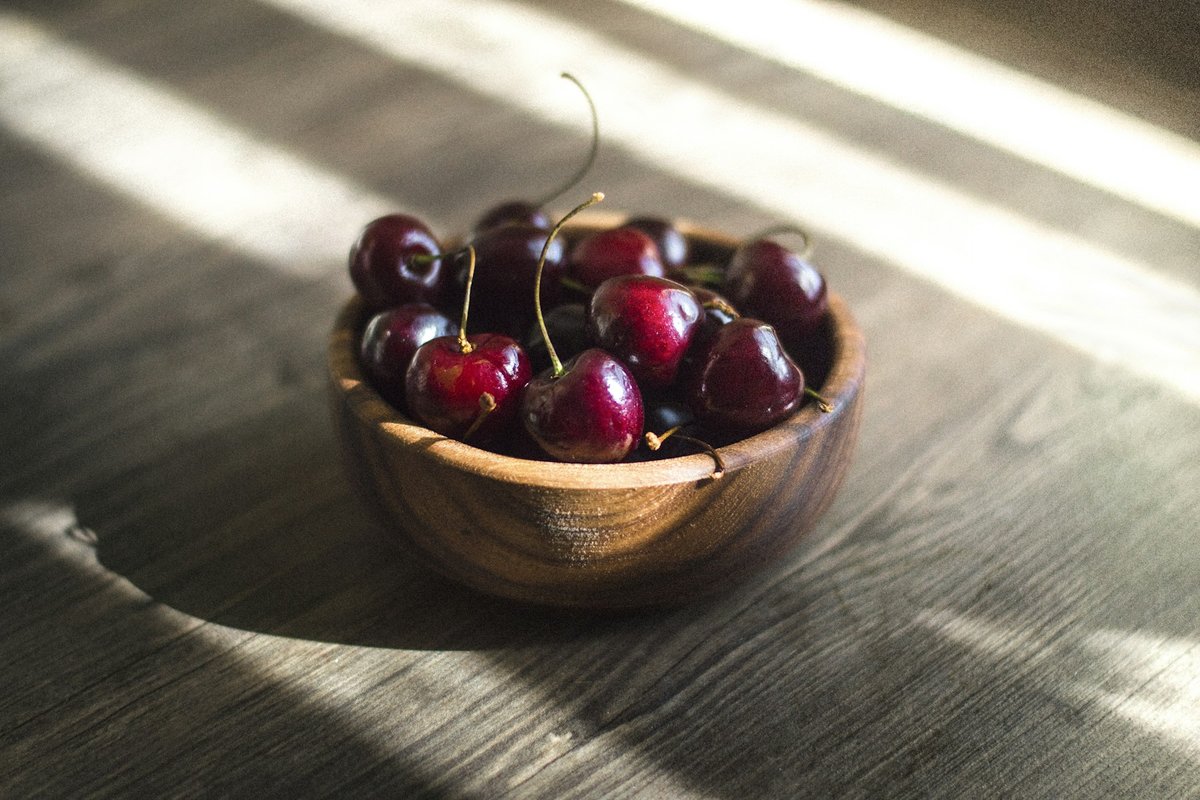 Bol en bois de cerises dans un rayon de soleil
