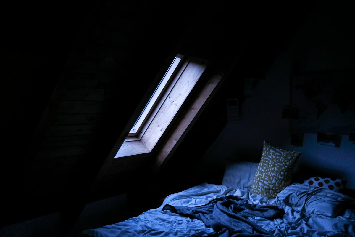 Petite chambre mansardée éclairée par une lucarne ouverte