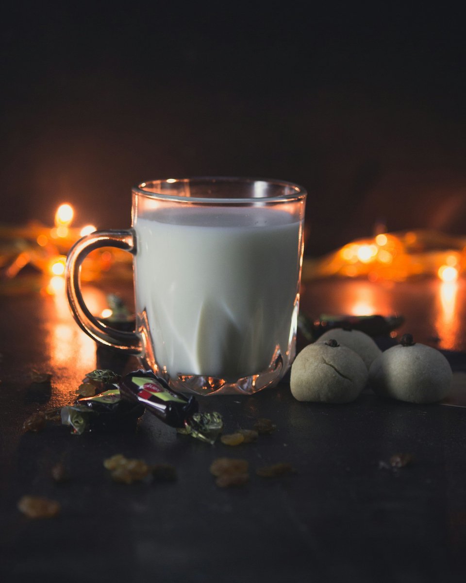 Verre de lait posé près de bougies allumées sur une table