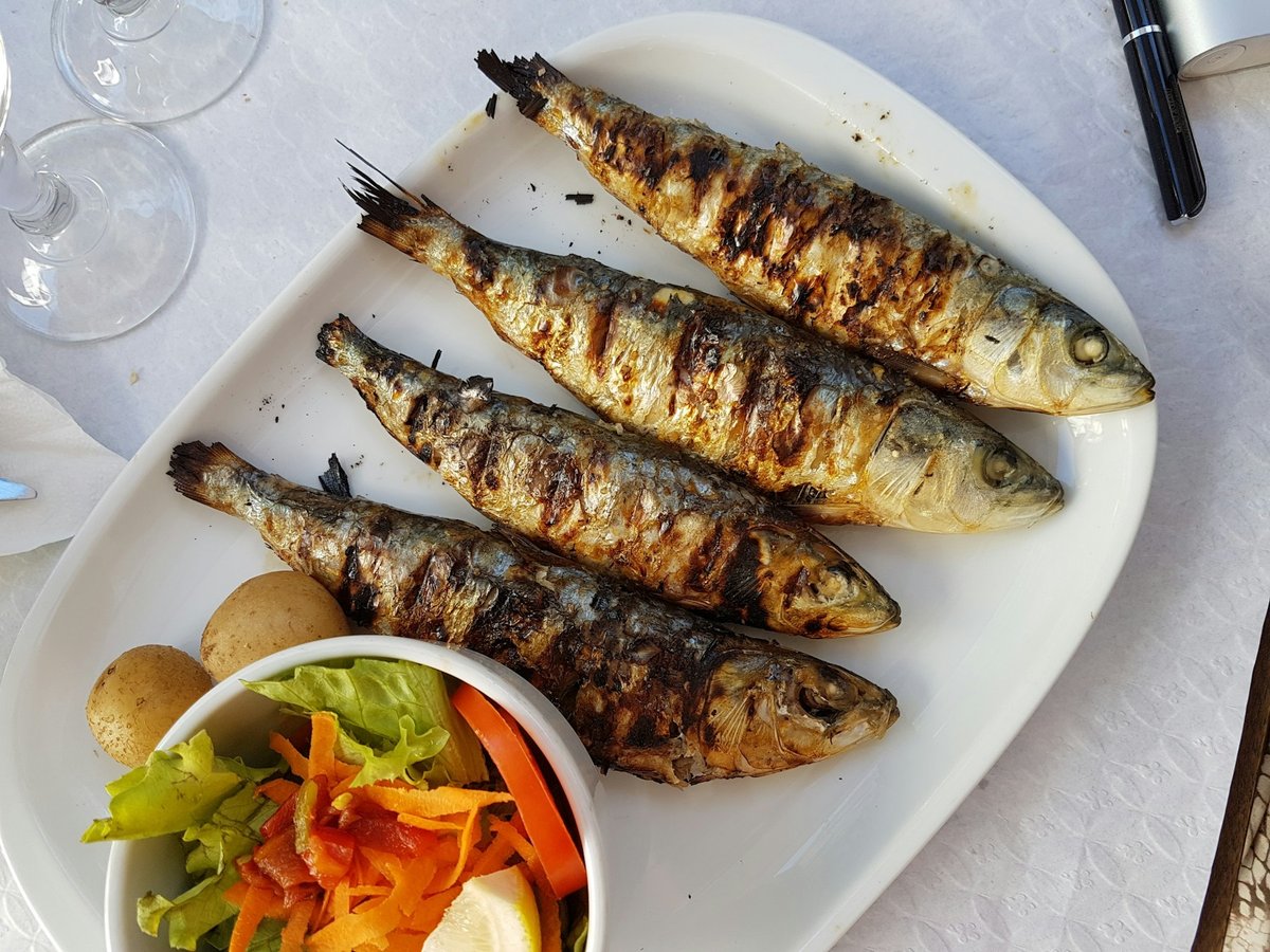 Sardines grillées servies avec des pommes de terre et une salade verte