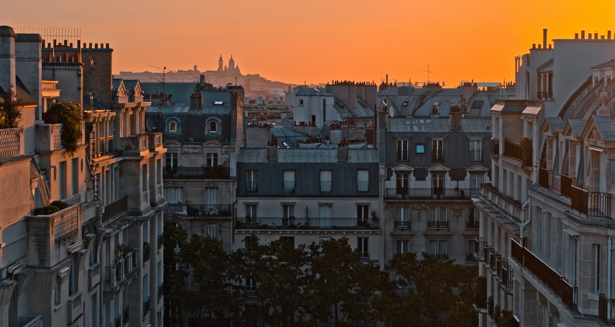 Toits de Paris au soleil couchant, ciel orangé